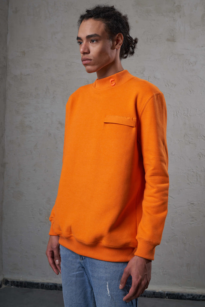 young black man wearing orange crewneck sweat with detachable wallet pocket. 