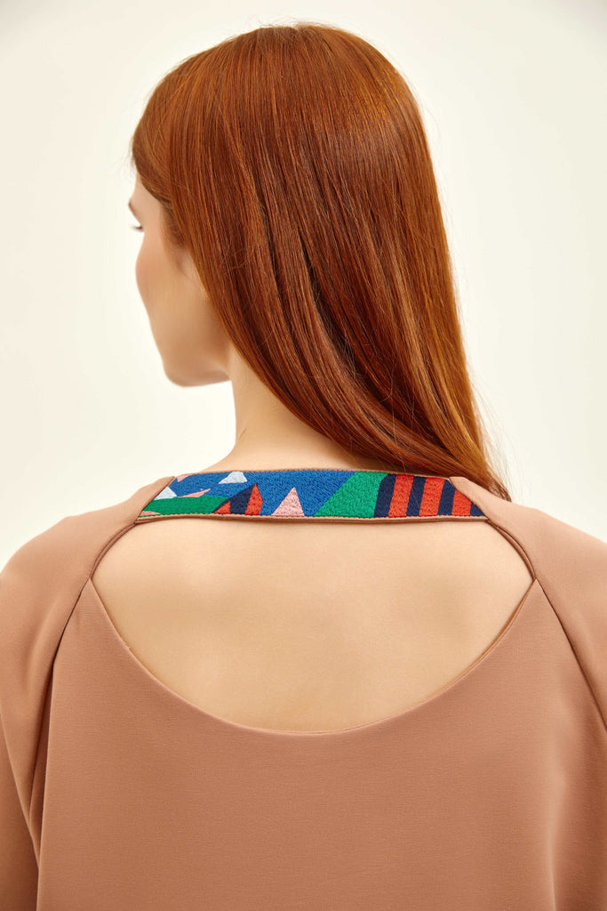 close shot of a back neck of a dress and a embroidery detail 