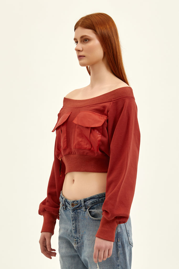 side of an off shoulder dark red crop top with an amazing midriff 