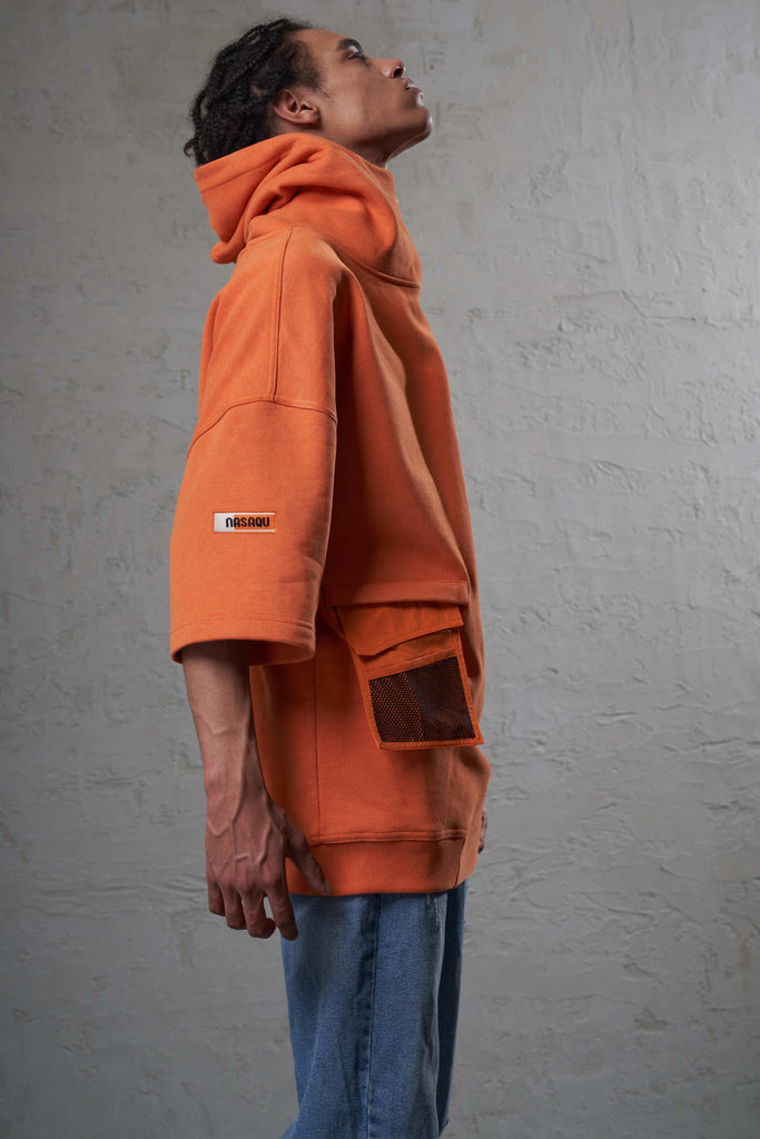 black man wearing orange color hoodie sweatshirt with short sleeves and wallet pocket  and denim looking up