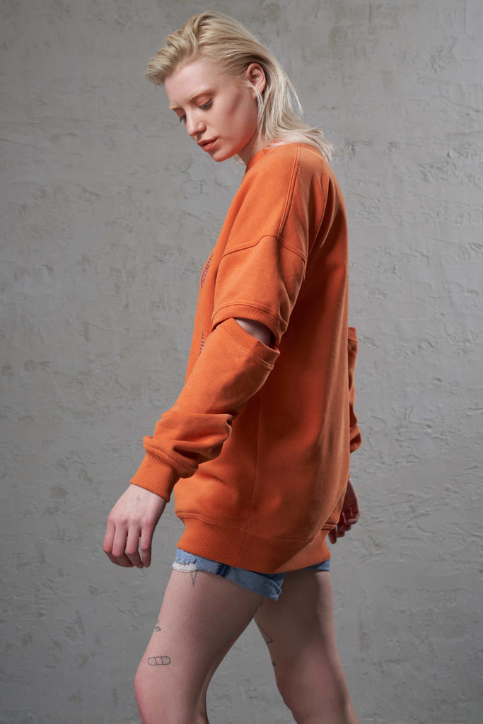 side of a ethically made cutout arms orange sweatshirt